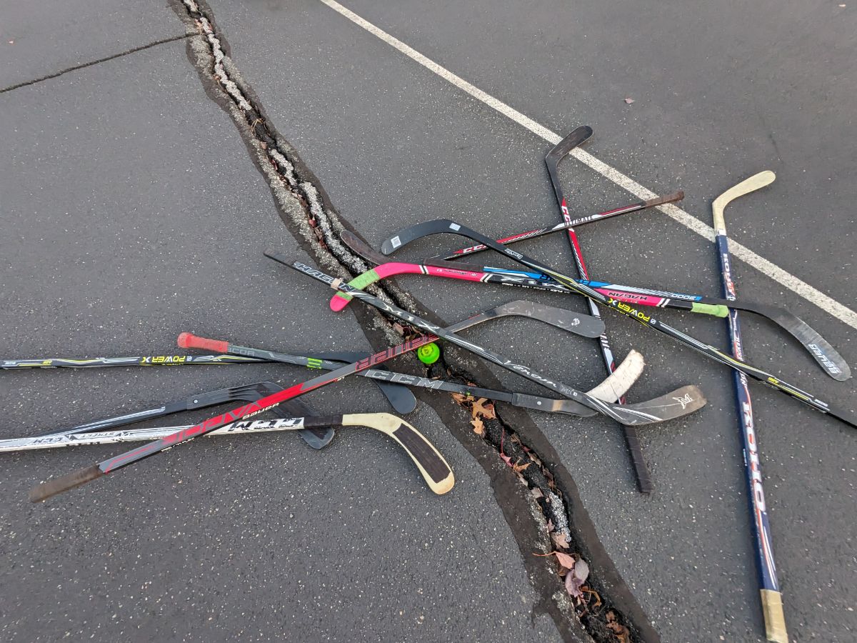 pickup hockey - sticks in a pile on the black top